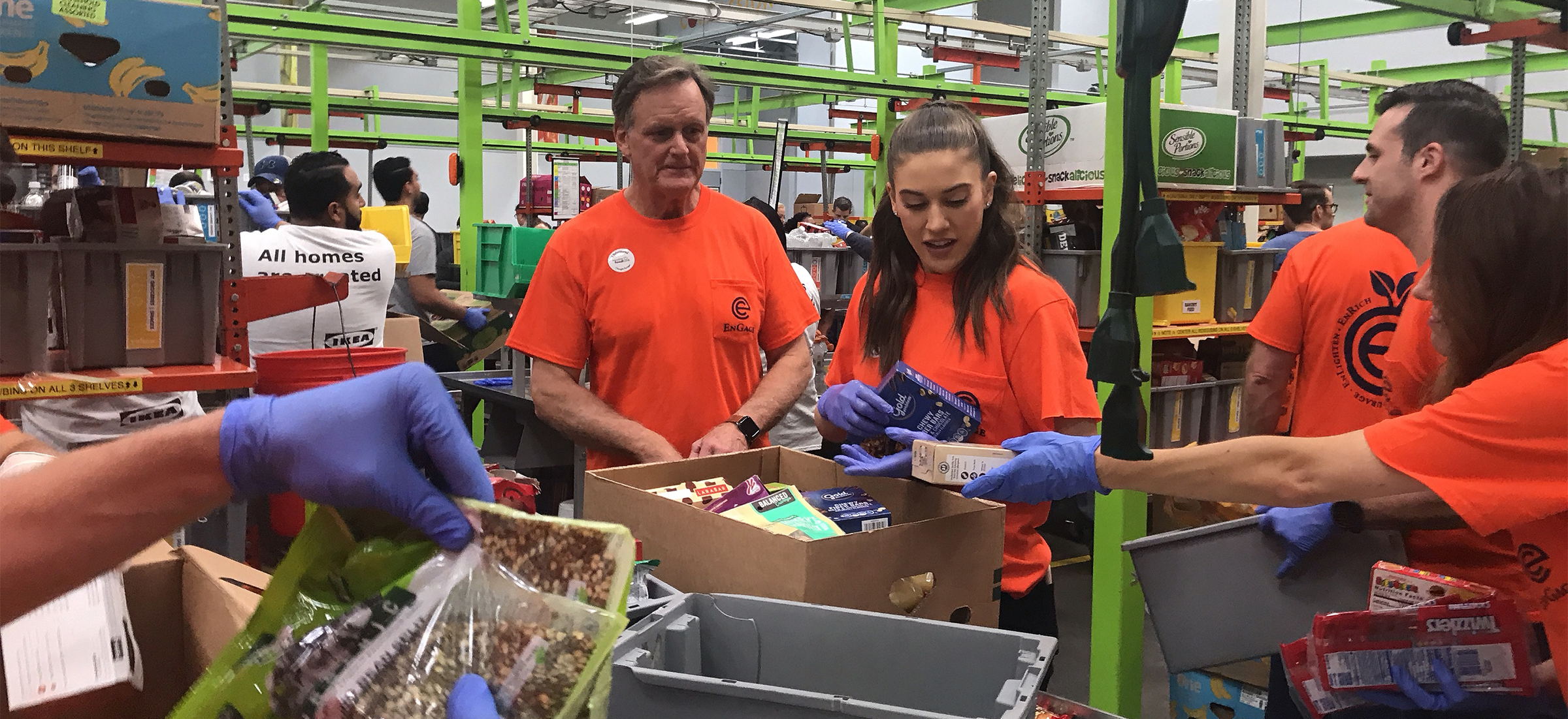 Marty Phillips and Meg Murphy oversee the contents of a box being filled with nonperishable food items.