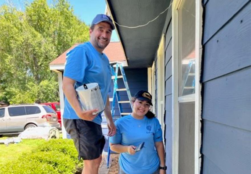 Craig Friou (L) and Madison Baez (R) paint the exterior of the Women’s Gateway Home.